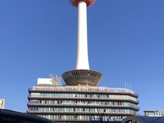 『京都タワー』の写真。

私たちが利用するバス停D1は左手にあります。
右手に「バスチケットセンター」があるので、地下鉄と市バスが
乗り放題になるお得な1日乗車券を購入します。（乗る回数による）