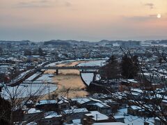 16:45です。ちょうど日が沈んでいくところです。
横手川が夕日色に染まってキレイ！

橋の上にたくさん人がいるのがわかりますか？横手の雪まつりの光景として有名な蛇の崎川原会場が橋の向こう側にあります。日没を、蛇の崎川原会場で迎えるか、横手公園で迎えるか・・・ちょっと迷いました。