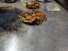 広島に、20時すぎに着いて、広島焼きを食べるべく、ホテルの方へと足をすすめる。
1軒目はお休み、2軒目は材料切れ、3軒目に入ったのが「のん」というお店。
すでに、店のママは店仕舞いしようとして、常連さんとお酒を飲んでいるタイミングで入ったのだが、快く受け入れてくれた。
すでに、できるメニューは限られているとのこと。
「キャベツはつぶすと、早く焼けるけど、水が出て美味しくない」と言って、ほとんどキャベツをつぶさずに焼いていた。
キャベツの甘みが生きた美味しい広島焼きだった。