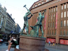 三人の鍛冶屋の像。

西端でマンネルヘイミンティエ (fi:Mannerheimintie (Helsinki)) 通りと交差する地点にある広場 (Three Smiths Square) に建てられている[2][5][6][7]。

彫刻家、フェリックス・ニュルンド (fi:Felix Nylund) によって製作され[3]、1932年に広場に設置された[8][9]。ニュルンドは、1913年、哲学者ユーハン・ヴィルヘルム・スネルマンの記念碑のコンペティションでこの彫刻作品を出している[8][7]。

彫像は、人間の労働や人間どうしの協力を象徴的に示しているものと解釈されている[8]。像は青銅を鋳造して造られたものであり、台座には赤色の御影石が使われている[8][10]。台座には、1944年2月にロシアがヘルシンキを空襲した際にできた弾痕が残されている[7]

bywikiちゃん、で、なんの為に造られたのかしら～？wikiちゃんのオシャッテいる意味が分かりません。