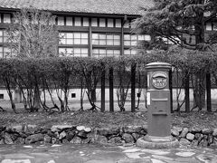 その先に、赤褐色に塗られた瀟洒な建物が見えてきた。
旧三重県立工業高等学校製図室として、明治４１年(1908)に建てられたもので、現在は松坂工業高校となっていた。
その敷地の東南に沿って流れる細い川は、松阪城の堀の跡だそうだ。
そして、この辺りは、かつて松坂城の搦手門があった場所である。