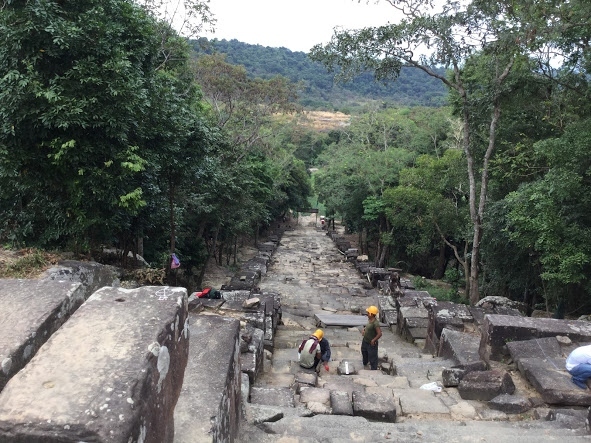②から、タイ側からの①の参拝用の階段を見る。補修工事中のようでしたが、降りていきます。<br />降り切ったところは、広場になっております。<br />対面の林の方に小屋があり、林に向かって小道があります。<br /><br />どの位、タイ国境に近づけるか行ってみます。タイ側の「2つの塔」（昔の火葬場だった？らしい）を見れたら、いいなぁと思いながら、進みました。<br />小屋から、年配の男性が出てきて、「ムスッ」とした顔で何かを言ってました。<br /><br />16年のタイ側の「2つの塔」の時に、軍人さんから、カンボジア側の写真撮っては、ダメと言われていたので、小心者の私は、これは、これ以上ダメという事かなと思い、引き返します。（拘束？？されちゃ、いやですから）<br /><br />観光客？地元民？の若いカップルが、私とすれ違い、林へ向かう小道を歩いて行きます。見ていると、何事もなく林に消えていきました。アレッて感じでした。<br /><br />16年の経験が無ければ、小屋の男性に「私も、もっと、行きたい」的な事を聴いていたと思います。<br />ここまで来て、小心者は情けないです。ただ、頭の中では、地理的に小道の先が、想像できたので、これはこれで満足です。<br /><br />たぶんダメと思いますが、もう1ッか所の方に挑戦？です。