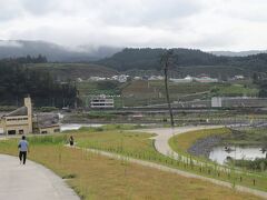 高田松原津波復興祈念公園　

「奇跡の一本松」が見えてきましたよ、、
左横に見える黄色の建物は『陸前高田ユースホステル』(震災遺構)
この建物のお陰で「奇跡の一本松」が残ったのではないかとも言われています、、
この公園が出来た時に震災遺構として一緒に残されました、、

同じく、震災遺構として残されたのは奥の白い建物「旧気仙中学校」と
「奇跡の一本松」の横に見える”橋脚”(ベルトコンベアー「希望のかけ橋」の橋脚)
「希望のかけ橋」は近くの愛宕山から土砂を運搬し、市街地のかさ上げや防潮堤整備などに使う土砂などを運ぶ為に使われました。ダンプだと9年はかかると言われたところ、ベルトコンベアー利用だと2年以内に運搬できたそうです、、

高台に見える住宅地は震災後、津波の影響を受けないであろう高台に移転された陸前高田の町です。
