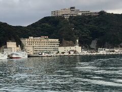 いよいよ「ホテル浦島」にチェックインします。

レンタカーで指定の駐車場へ。
とても広くて大きな駐車場です。
入り口で指定の場所に停めるとマイクロバスで直接ホテルか、船で上陸したい人は最寄りの船着き場まで連れて行ってくれます。

もちろんカメの船に乗りたくて船着き場で降車、遠くに巨大なホテルが見えます。
山の上にあるのが今日宿泊する「山上館」です。