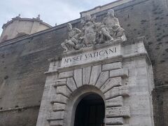 ローマ最初の観光はヴァチカン美術館　すでに結構な人が並んでいました
ガイドさんと合流し受信器の周波数を合わせ、順番に荷物検査などを受け、エスカレーターとスロープを登り… ガイドさんの持つ旗を目印に、はぐれないようについて行きます