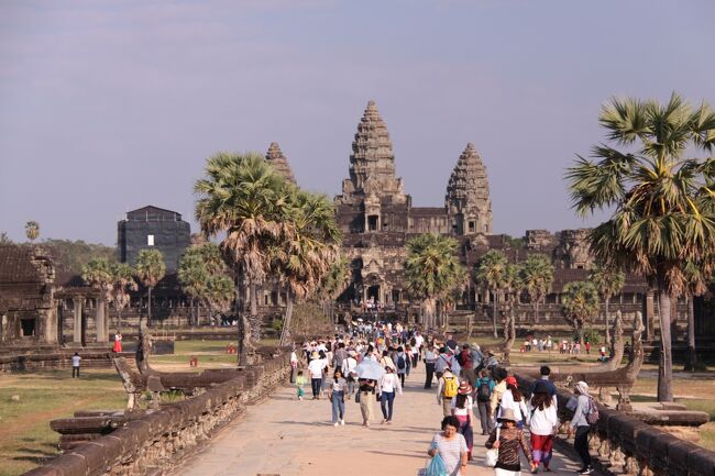 ■憧れのアンコールワット<br />アンコールワットはヒンドゥー教の寺院として作られ、１６世紀後半仏教寺院に改修されました。<br />アンコール遺跡群の中でも大きく見事な彫刻や様式を見せてくれます。<br />カンボジア国旗には国の象徴としてこの寺院が白く描かれています。<br /><br />■ アンコールワットは東西方向に建設されていて、外周、東西1,500メートル、南北1,300メートルの広大な敷地を有します。<br />遺跡全体は幅190メートルの環濠で守られており、日本の城のお堀のような風景が見て取れます。<br />境内は参道を渡って西参道正門から入場しました。メインの参道は現在修復中のためフロート式の仮設橋を渡っていきます。