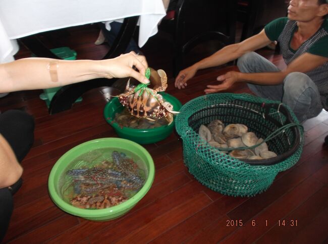 思い出を胸に：ハロン湾で海鮮物を小舟で売りに来た親子、お母さんが何かをお薦め＆値段交渉。