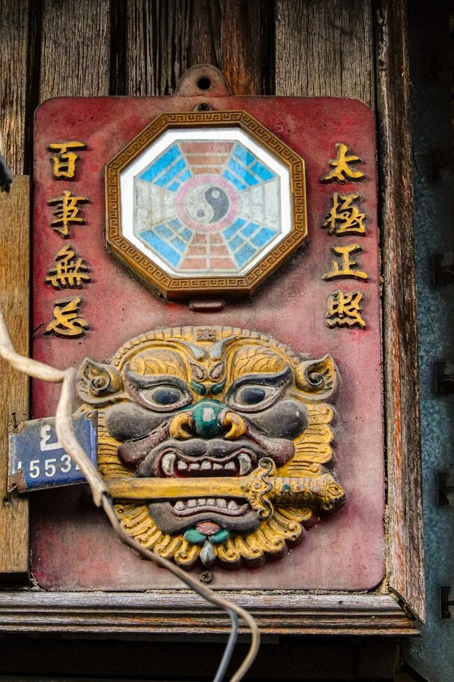 黄色の壁の建物にあった、中国の魔よけの八角鏡