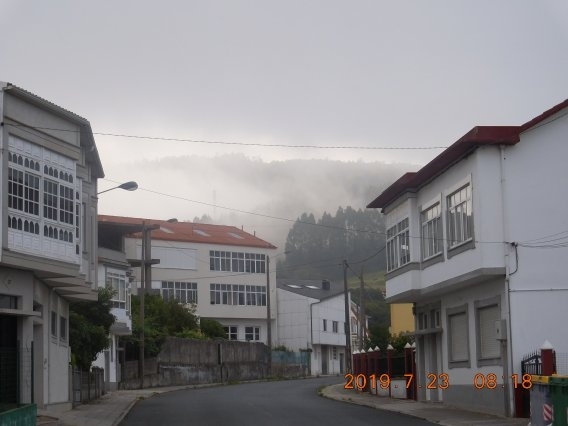 　次の町中で矢印を見失ってしまった。ちょうどそこには教会があって、事務室には早朝だけど明かりが灯っていて仕事をしている女性がガラス越しに見えた。コンコンとガラスを叩いてカミーノを教えてもらうことに。でもこの女性はカミーノは知らなかった。わざわざ出てきてくれて、更に近くの店まで走って行って教えてもらっていた。親切なセニョーラにムチャグラシアスと言って歩き出すが、ハッキリとしなかったので半信半疑。でも暫く歩いて行くと黄色い矢印を発見できて一件落着する。海が近いのでか、山全体を朝靄が覆っていて中々幻想的な風景が町の向こうに見えている。<br /><br />　次の町外れにスーパーGadisがあったので、でかい飲むヨーグルト330mlとバナナの小さいのを５本仕入れる。２ユーロ弱。店先でヨーグルトを飲んでいると、離れたところを巡礼が通り越して行ったな。予想したより巡礼は多そうだ。<br />