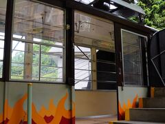 駅前から、とりあえず、天上山へ向かうことにする。
ちょうど、河口湖周遊レトロバスが出るので、これに乗って天上山公園カチカチ山ロープウェイ乗り場へと向かった。
乗り込んだロープウェイには、屋根の上に狸の飾りが置かれていた。
ここは、昔話で有名な『カチカチ山』の舞台だと云われているのだ。