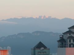 ３日目　12月28日（金）　早朝：ホテルからの眺め　

■山頂に輝く建物は？　
　ホテルの外には、KLCC公園越しに“ペトロナスツインタワー”が聳え、視線を釘付けにされるほどの存在感があります。爽やかに目覚めた早朝、ホテルからペトロナスツインタワー越しの遥か右手後方、朝日に輝く山頂の建物らしきものに目が留まりました。

　「これは何ぞや…」と地図を眺めても直ぐに分からず、後で確認したところカジノ等があるリゾート地（ゲンティンハイランド）であることが分かりました。ホテルのランク等に興味はありませんが、短い滞在時間の中で色々なものを見たいという関心から、滞在ホテルからの眺望等には拘っています。
　
