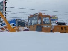 　除雪車が動いていました。道路の雪を吸い込み、路側帯に排出しています。歩道から見ると雪で除雪車の下が見えません。