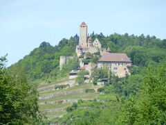 B27を7kmで鉄腕ゲッツが半生を過ごした城・Burg Hornbergホルンベルグ城に到着した。
ここで、ハインスハイム城で食べられなかった昼食を食べる事にした。

古城は当然ながら、皆高い所にあり、狭い道を上り下りする。
対向車が来ると、もう相手に任せて、当方は出来るだけ動かない様にしている。

葡萄畑に囲まれた城に上がってみると、駐車中の車が多い。
どうやらここでも結婚披露宴が行われているようだ。レストラン棟横のBurghof中庭に天幕が張られて、着飾った人たちがうろうろしている。
幸い、裏手の道路脇に駐車スペースが空き、直ぐ車を置く事が出来た。

レストラン棟に向かうと、本日の主役である新郎がポルシェを運転してやってきた。自分の車なのか、借り物なのか、ともかくドイツの若い人にも、結婚には一つの型があるのだろう。今日は花嫁を見るチャンスが無かったが、ここまで各地で新郎新婦を見てきた。麗しの春は結婚の春でもあるようだ。

写真はBurg Hornbergホルンベルグ城の遠望：格好が良い城だ。