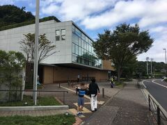 自宅から車で30分弱、ミュージアムに到着。鉄筋コンクリート３階建ての立派な施設です。

新型コロナウイルス感染拡大防止緊急事態宣言が発令されているので、入場券は完全日時指定入館制となっており、ローチケでネット予約、Loppiで購入しました。

施設自体に駐車場はなく、登戸駅からの直行シャトルバス利用が推奨されています。しかし、我が家は微妙に近いので自家用車で訪れ、周辺のコインパーキングを利用しました。コインパーキングは近隣に数カ所ありますが、料金は高め、どれも数台しか停められない狭いパーキングですので、やはりシャトルバス利用が安心です。私たちは開館時間より早めに着いたので４カ所のパーキングをチェック、一番安い駐車場に停めることができました。