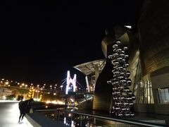22時ごろのグッゲンハイム美術館は、光のリフレクション具合が絶妙でした。

美術館の建物、屋外のメタル系作品、池(作品が仕込まれている)が照明を反射してキラキラ～

遠くに見える橋のアーチ部分も作品で、ライトアップされています。