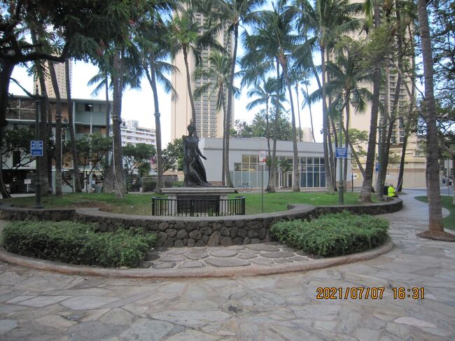 プリンセス カイウラニ像<br />孔雀を連れた若い女性の銅像が、ワイキキのほぼ中央、クヒオ通りとカイウラニ通りの差点、バス停の前に置かれています。ハワイ王国最後の王位継承権を与えられたカイウラニ王女の像です。このあたりには「アーイナハウ」と呼ばれるカイウラニが住んだ邸宅がありました。<br />　<br />カイウラニは1875年10月、カラカウア王の末の妹にあたるリケリケ王女と、スコットランド人アーチボルト・クレグホーンの一人娘として生まれました。カラカウア王は姪の誕生を心から喜び、ホノルル中、全ての教会の鐘を鳴らして祝ったとか。カラカウア王の戴冠式に出席するなど公的な生活をしながらも、子馬を乗り回したり、幼少のときを楽しく過ごしたカイウラニは、将来の女王としての教養を身に付けるべく1889年、13歳の若さで渡英。汽船と大陸横断鉄道を乗り継ぎ、更にニューヨークから大西洋を渡りリバプールへ。ホノルルからロンドンまでの道のりは1カ月余を要しました。<br />　<br />家族や友人から離れ、生まれ育った南の島・ハワイを後にしての長旅に、まだ幼い王女はさぞかし不安を覚えたことでしょう。しかし、英国留学中の王女に対する将来への期待とは裏腹に、母国のハワイ王国はその末路に差し掛かります。伯父カラカウア王は、西欧人の砂糖業者を中心とした経済界の人たちに翻弄され王権を揺るがされ、その権力を弱めていきます。小さな王国に見切りを付け、米国への併合を求める親米派の動きが年々強まり、王権を脅かし始めたのでした。<br />　<br />王は体調を崩し、1891年1月サンフランシスコでの静養中にこの世を去ります。カラカウア王の棺がホノルル港に着くや否や、リリウオカラニは兄の葬儀を待つことも許されず、即刻ハワイ王国8代目の女王になるべく宣誓を行いました。その女王も2年間在位した後、米合衆国への併合を求める勢力に屈するように、王権を放棄せざるを得なくなり、約1世紀弱続いたハワイ王国は終わりを告げ、後継者として指名されていたカイウラニが女王になることは叶いませんでした。<br />　<br />カイウラニは1897年に帰国の途につき、サウサンプトンからニューヨークに到着した後、王国の復活を米国政府に直訴していた、ハワイ王国最後の女王であった伯母リリウオカラニにワシントンで再会を果たし、クリーブランド大統領にも謁見しています。ホノルル港に着いた王女は、その足でダウンタウンの丘の上にあるマウナアラの王家の墓に、亡き母リケリケを訪ね、懐かしいワイキキの家に8年ぶりに戻りました。その後ハワイ島のパーカー牧場滞在中に体調が急変。ワイキキに戻り、23歳の短い生涯を終えました。孔雀を連れた王女の銅像はなぜか悲しみを帯びた様子にも見えます。<br />　