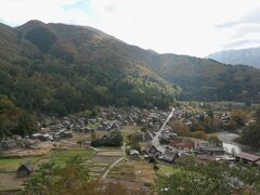 さらに東方向に移動すると、集落を貫く道路が直線に延びるのがはっきりしてきた。
その右側に庄川が流れ、合掌造りの多くは道路の左側にある。
南向きなので逆光気味になっている。
写真を撮るには、午前中の早めの時間帯か夕方近くの方が良いかもしれない。