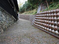 廻船問屋瀧田家の前、デンデン坂。壁面には常滑焼の焼酎瓶が使われて、路面には常滑焼の廃材が敷き詰められています。