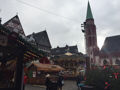 「レーマー広場 (Römerplatz）」に到着。
「レーマー広場のクリスマスマーケット（Weihnachtsmarkt am Römer ）」が開催されています。
こちらのクリスマスマーケットは、1393年から始まったと伝えられており、現存するドイツ最古のクリスマスマーケットの中の１つです。クリスマスマーケットの歴史には諸説あります。中世の人々は街で開かれる市場で物々交換し、生活必需品や食料を手に入れていました。キリスト教下で生活をしていた当時、教会や領主の政令により庶民の食糧取引や食事は規定されていました。これは収穫期から次の収穫までの期間、計画的に備蓄消費をする必要があるからです。
