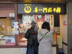 と、ここで奥さんの足が止まり、列に並びます。十三に本店がある和菓子の喜八洲総本舗が券売機の隣にありました