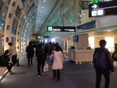 羽田空港への到着後は、52番ゲートから制限エリアへ。
到着口に向かう通路は、大きなスーツケースや手荷物を持つ人で溢れています。