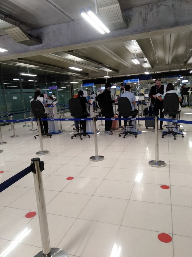 バンコクスワンナプーム国際空港に無事に到着し入国審査の前に陰性証明書や宿泊や送迎の手配がちゃんと出来ているかのチェックがります。<br />降機後通路を進んでいくと椅子が並んでいるので順番に座り書類が揃っているか順番にチェックをしてもらい、揃っている人から順番にカウンターに進みます。<br />どうも各病院から看護婦さんが出張して来ている様で、係の人によって着ているユニフォームが違います。皆さん自分の勤める病院の名前が刺繍してある看護服を着ていました。<br />