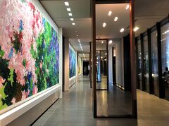 東京・虎ノ門『Andaz Tokyo』1F

ホテル『アンダーズ 東京』のアートの写真。

写真右手に車寄せがあります。回廊に飾られた油彩は、
人気の若手アーティスト内海聖史さんの油絵で全部で5枚あります。

変化する緑色をベースに様々な色彩がその上を水のように流れ、
日本の四季が感じられるようになっているとのことです。

〇 「あたらしい水」（作者：内海聖史氏）

こちらのピンクのお花の絵の先にロビーフロア行きの
エレベーターがあります。