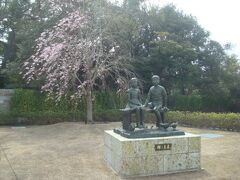 鎌倉文華館鶴岡ミュージアムの敷地に「輝く未来」の像。奥に咲いているのは枝垂れ桜でしょうか。
