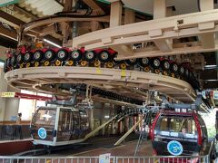 ロープウェイ乗り場では搬器が一旦停止状態となり、扉も大きく乗り降りしやすい。
単線複式のワイヤロープは乗り場の下に引込み駆動、張力を調整する構造。
2本のワイヤ間の距離、吊具の幅が搬器より広いのがフニテル式の特徴だ。耐風性が上がったらしく、運行制限基準が20m/sから30m/sになり、強風による年間運休日が30日から半分程に減ったようだ。
