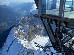 ツークシュピッツェ頂上のローブウェイ駅よりアルプスの連峰と万年雪を望む。ツークシュピッツェ山頂付近はドイツ最高峰のスキーゲレンデがあります。夏でもスキー滑走が可能。コンベンション中スキーをする人はさすがにいませんでしたが、貸し出し用のそりで楽しむ人たちが続出していました。

山頂展望台は防寒していただければ、本格的な登山の恰好をすることなしに観光できます。極端な話、ハイヒールでも来られます(そんな人は実際いませんが）。スキーゲレンデは、山頂展望台から標高2500mほどにある氷河の広がる場所に展開し、Gletscherbahnhofという登山列車の終着駅もあります。ここから山頂展望台までは距離の短い別のロープウェイが運行しています。登山列車はスピードがゆっくりなので、高山病を避けたい人にはお勧めです。ロープウェイは高速なだけに、標高の高いところに自信のない人や高所恐怖症の人は避けたほうがいいでしょう。
登山列車、ロープウェイともにバイエルン・ツークシュピッツェ登山鉄道会社の運営で、通し切符で好きなものを選んで利用できます。