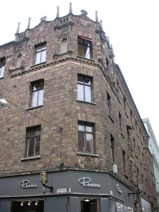 さらに進んで角にたっていたレンガなのかタイルなのかが気になったこちら。<br />一番上をよ～～く見ると鳥かなあ。なんだかいろいろ付いているぞ。角の入り口上というか２階の窓の下の花の文様もステキ♪<br />