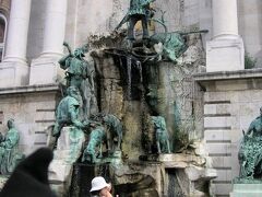 漁夫の砦から王宮へ向かうと、途中に銃弾の跡と思しき穴がいくつもある建物が。ん～、いろいろとあったんですね。
こちらのマーチャーシュ王の泉で写真を撮り、王宮にある国立図書館のリフトで下へ。