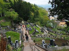 急に坂道が途絶えて階段が現れ、眼下には墓地が広がっていた。
人の流れに沿って階段を降りていくと…