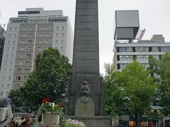 大通公園の西5丁目の中央にオベリスクのごとくそびえる石碑は昭和14年に建立された「聖恩碑」です。碑の正面には「聖恩無彊」(せいおんむきょう)の四文字が刻まれています。