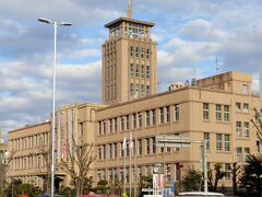 JR大牟田駅前のクラシカルな建物は「大牟田市庁舎」です。
市役所の焼失の後、1936年（昭和11年）に落成したそうです。
この写真は斜め方向から撮影したので、今一つわかりにくいのですが、左右対称のバランスの取れた四階建て（写真では一階部分が写っていません）で、中央に塔屋が置かれた建物で、第二次大戦の空襲にも耐えました。
大牟田市のシンボル的建物ですが、建て替えの話も出ていて、賛否両論です。確かに横に長く、増築を繰り返しているので、段差を解消するためにスロープがあったり、複雑な構造になっています。
エレベーターも多分後付けなので、正面玄関からかなり離れた端の方にあります。
市民も職員の方たちも使いにくい建物かとは思うので、建て替えの必要性はわかりますが、この重厚な建物、どんな形でも良いから是非残してもらいたいと思います。