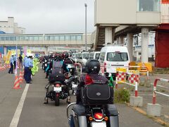 13時55分、ようやく下船、北海道に上陸！

けど、バイクの列はいっこうに動きません。

上から見えたおまわりさんたちが、一人一人に声をかけて、何やら渡してくれています。
さらにガソリンスタンドにあるような空気入れを持って歩いている人もいます。

まず女性警官が旗とビニール袋をくれて、男性警官が
「今日はどちらまでですか」「事故が増えているので、シカの飛び出しに注意してくださいね」
と声をかけてくれました。
人や車じゃなくてシカ？
前に道東でシカを見たことあるけど、人や車に見つからないように逃げていったので、まさか、と思ったのですが...

ところで、あの着ぐるみは？