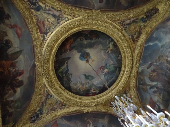 戦争の間<br />Le salon de la Guerre<br />The War Room<br /><br />天井画。わかりにくいけど、シャンデリアが垂れ下がっている中央には擬人化されたフランスの女神がいて、彼女のもつ盾にはルイ14世が描かれている。<br />La France foudroyant ses ennemis<br /><br />https://galeriedesglaces-versailles.fr/html/11/collection/guerre.html<br />https://galeriedesglaces-versailles.fr/html/11/collection/c37.html