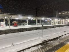 水戸からJRで県境越えて福島県に入り、終点郡山へ。ここからはバスで行こうと当初考えていましたが、会津若松行きの電車が10分後にあるようなのでこのまま電車で行くことにしました。この電車、本来もっと早い時間に来るはずが大雪の影響で遅れてこの時間になったようで、そこで初めて「雪」の存在を意識する。そして入ってきた電車、異世界から来たみたいに雪まみれ！

で、到着した会津若松駅、雪深っ！！そういえば会津若松で行きたい施設の営業状況を尋ねるために電話したとき、「朝は雪が凍って階段が滑るので」とか言われてそーかー雪降るのかー、とは思ってたけどずっと太平洋側にいたから想像がついていなかった。会津若松めちゃ雪国じゃないか！