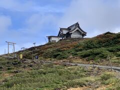 御釜の反対の方を見上げると、神社が見えました。
登ってみよう。上の方は風が強く吹いています。