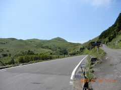 桃岩登山口 駐車場

阪急交通社の豪華バス菫号での北海道一周ツアーで来ているが、
離島へフェリーが有るので、小型バスだし来れるのだろうに、離島は何かバス会社の既得権益の為か、現地の観光バスに成っている。
道奥に、桃岩登山口 駐車場のバスが見え、
その道を奥に行くと、桃岩展望台コース登山口に成る。
奥に「桃岩」が見える。　現地の人はオッパイ岩ともいうそうだ。