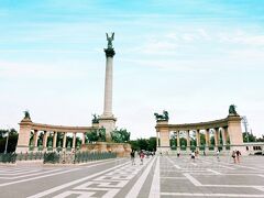 【英雄広場(Hosok tere)】
世界遺産(「ドナウ河岸とブダ城地区およびアンドラーシ通り」として)
 
ハンガリー建国1000周年を記念して1896年に造られたブダペスト最大の広場。中央の塔は、高さ35mその高さ35mの頂点にある像は大天使ガブリエル。
４体の大きな像は、向かって左から『労働と繁栄』『戦い』『平和』『学問と芸術』を表し、柱の間にある14の像は、芸術家や国王など、ハンガリーの英雄たちが並ぶ(by 地球の歩き方)