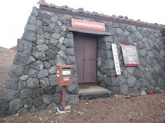 富士山頂郵便局　場所は時計だと5時半位の位置です
暴風雨に負けない建物の造りですね
6時～14時まで　あと15分位で開くようですが、この後の天気が心配なので進みます　限定の消印とかあるみたいです　