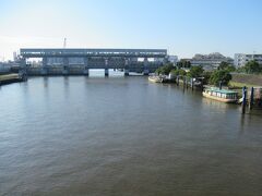 一之江駅から5分ほど、新今井橋から眺めた新中川に造られた今井水門の様子です。
新中川は江戸川区と葛飾区を流れる8㎞程の人工河川で、度重なる周辺で起こった浸水を防ぐために開削、1963年に完成した川です。河岸には屋形船やモーターボートが多数係留され、川沿いには遊歩道が設置されていました。