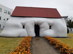まずは十和田市現代美術館に行きたくて、七戸十和田駅に12:15頃着、ここからなら12:29発のバスがあり、40分位で美術館前に到着するのでちょうどいいなと思いました。
そして、帰りも15:20発の七戸十和田駅行きに乗車すれば、新幹線の新青森方面発に乗れそうです。

でも、美術館って2時間で回れるかしら？せっかく見るならゆっくりしたいよねって考えて、七戸十和田駅前で美術館に行くためだけにレンタカーを借りる事にしました。車なら20分程で着くし荷物も乗せておけるしね。帰りも慌てなくて済むし。料金は3時間位でポイント等を使い5000円位でした。3人なのでバスを使ったのと同じ位でしょうか？

駐車場は200円だったけど、無料になる券を頂きました。
まずは外のアート広場から、これはファットハウス、中に入ると流れる映像で「私は家？それともアート？」と語りかけますよ。