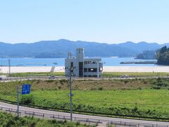 祈りの丘の東側には、震災遺構の高野（こうの）会館。
志津川湾のその向こうには微かに南三陸ホテル観洋の姿も見える。