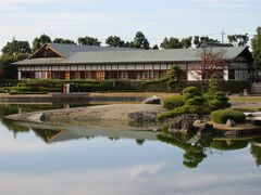 日本文化伝承の館 こしがや能楽堂（埼玉県越谷市花田）が、生け垣の向こうにあります。