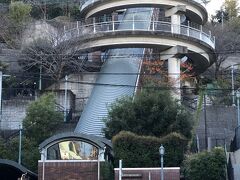長崎市南山手町『グラバー園』のグラバースカイロードの写真。

らせん階段（スロープかな？）でも行けますが、楽をします。

エレベーターに乗ります。

平成14年に完成した「グラバースカイロード」は、日本で初めて
「道路」として位置づけられた”斜めに動くエレベータ”。
路面電車の終点「石橋」近くの乗り場から2分ちょっとのエレベータの
旅を終えると、目前には青空と坂の風景が広がります。
高さによっていろんな表情を見せてくれる坂の街・長崎ならではの
楽しい体験です（無料）。

＜乗り場＞
路面電車「石橋」から徒歩2分

＜時間＞
往復時間約5分

＜運転時間＞
午前6時～午後11時30分