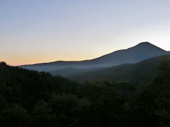 明けて9月29日、旅行二日目の早朝です。
時間は午前5時33分、カーテンを開けると目の前に諏訪富士（蓼科山）と八ヶ岳の絶景が現れました。
この日の朝は雲一つない快晴です。蓼科山の左裾野の端が早くも明るくなっており、今しも日の出が始まりそうな気配でした。