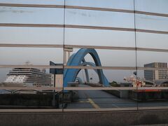 名古屋港水族館のビル壁のガラスに映っているセブンシーズ・エクスプローラーと青いポートブリッジ