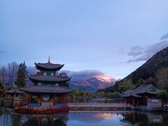 黒龍潭から眺める玉龍雪山。少し雲がかかるものの山頂も見える。日の出から数分、山頂付近が白く輝く。美しすぎて感動した。